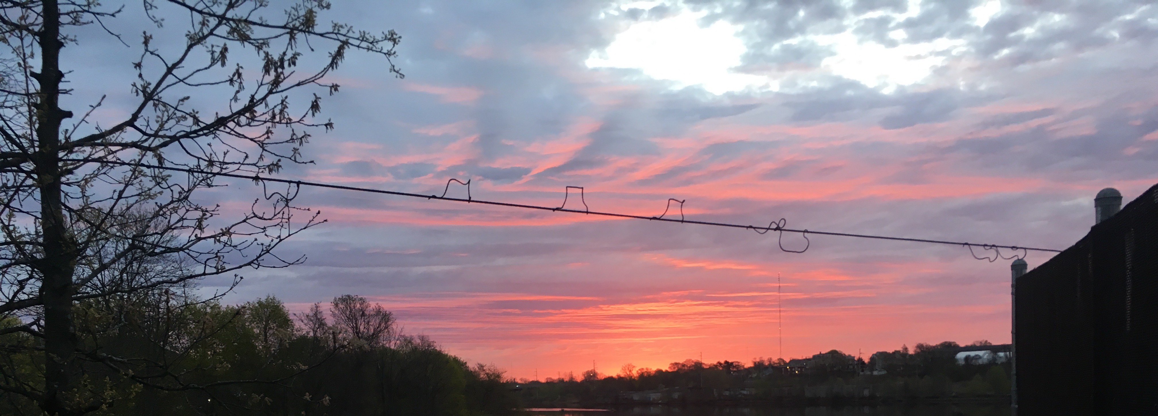 A photograph of a sunrise over a riverbank